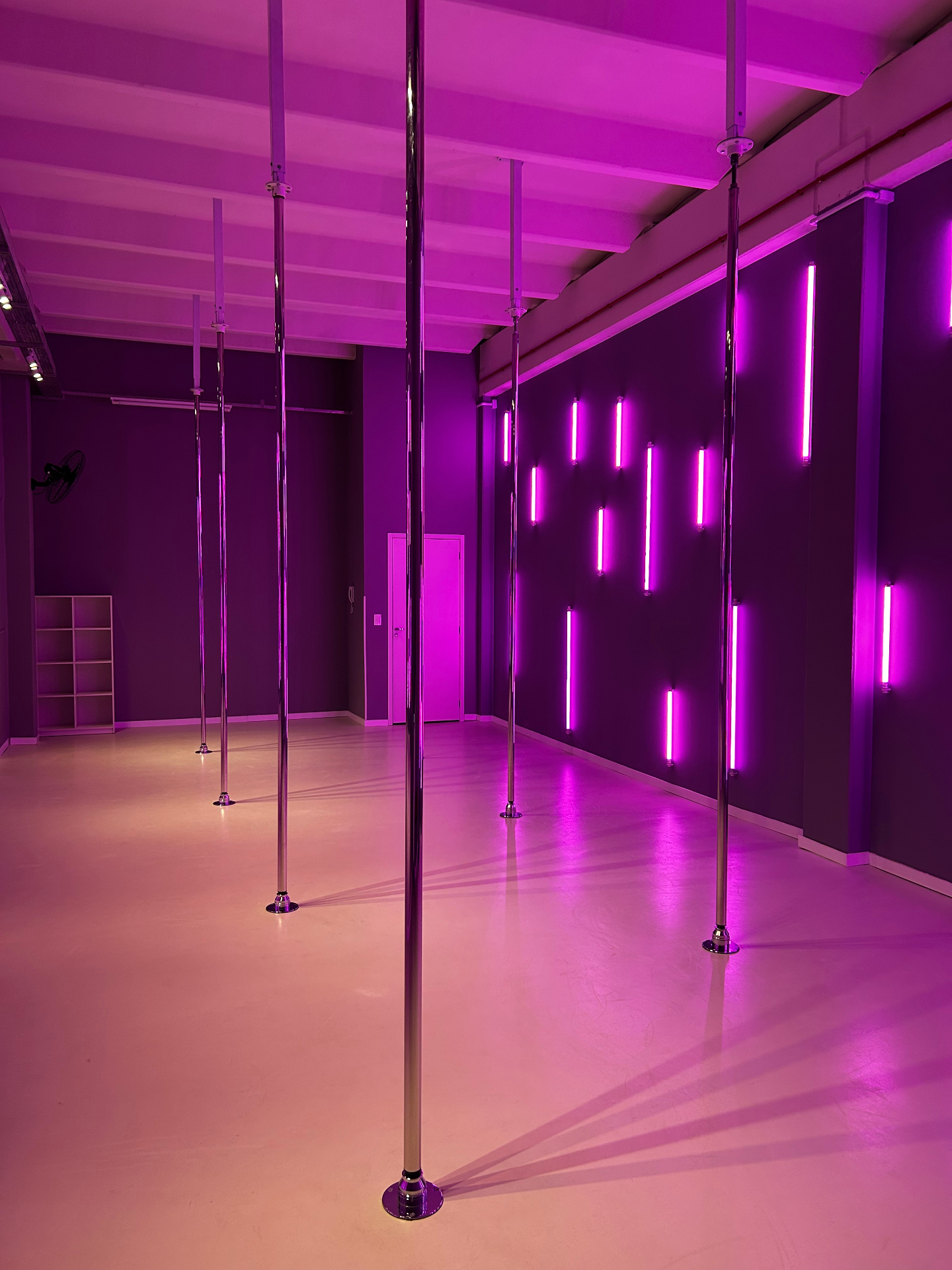 Mulher em pose de pole dance com luz neon magenta